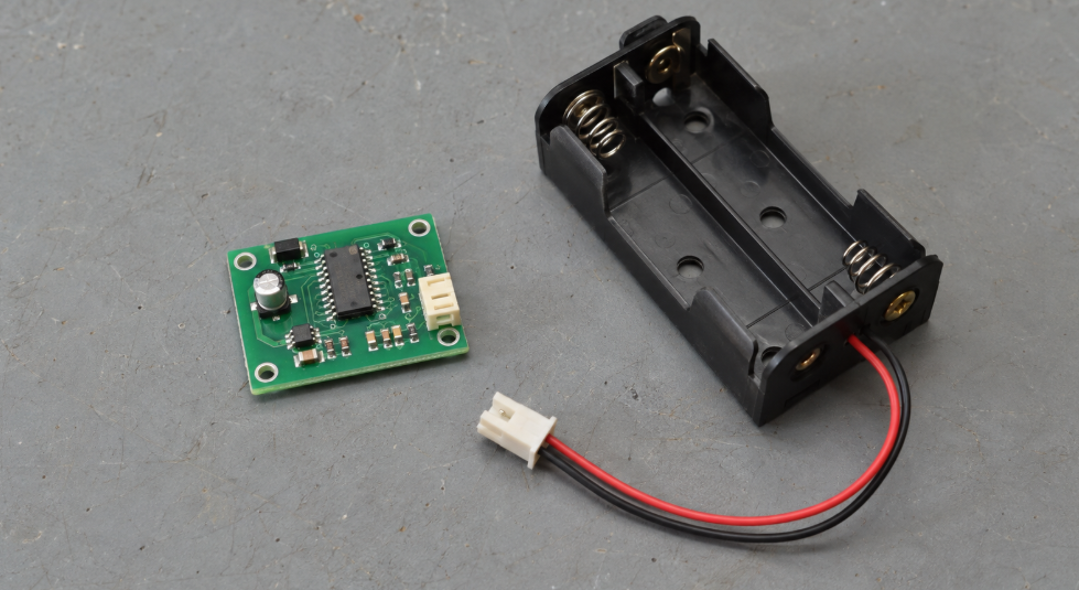 PIC vs AVR: Which Microcontroller Should You Choose? 3 Small Controller Board Beside An Empty Battery Holder
